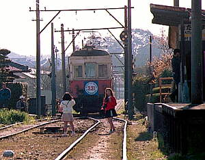 電車が走り去った後線路上で遊ぶ少女
